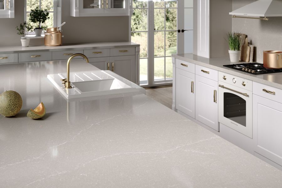 Landhausküche in weiß und beige mit goldener Armatur und goldenen Griffen