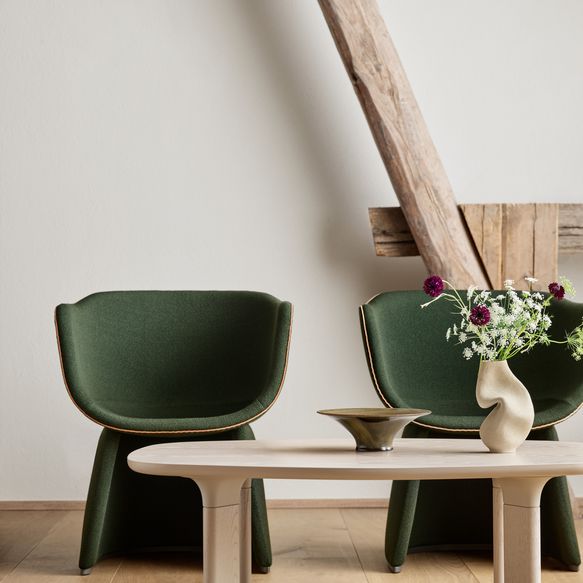 Zwei grüne Stühle mit Stoffbezug und hellem Holztisch