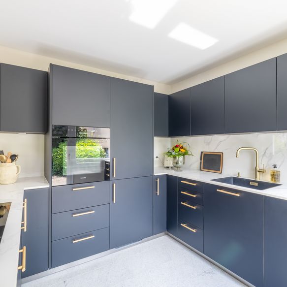 Dunkle moderne Küche mit goldenen Griffen