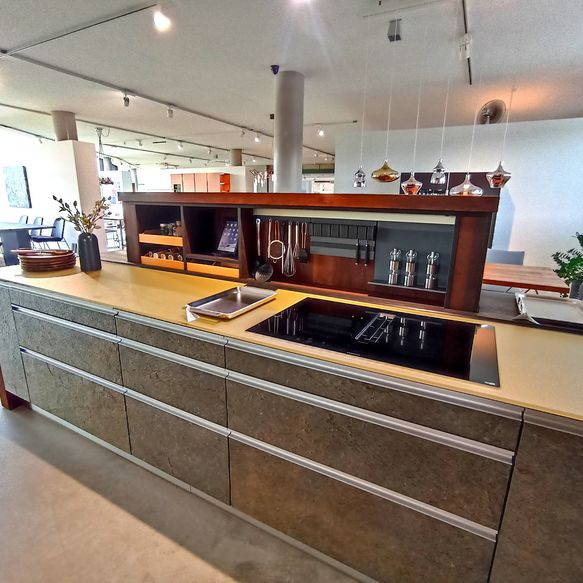 Hubinsel aus Holz mit goldener Arbeitsplatte und Steinfronten