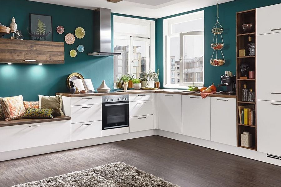 Klassische weiße Küche in L-Form mit Holzarbeitsplatte und integrierter Sitzmöglichkeit