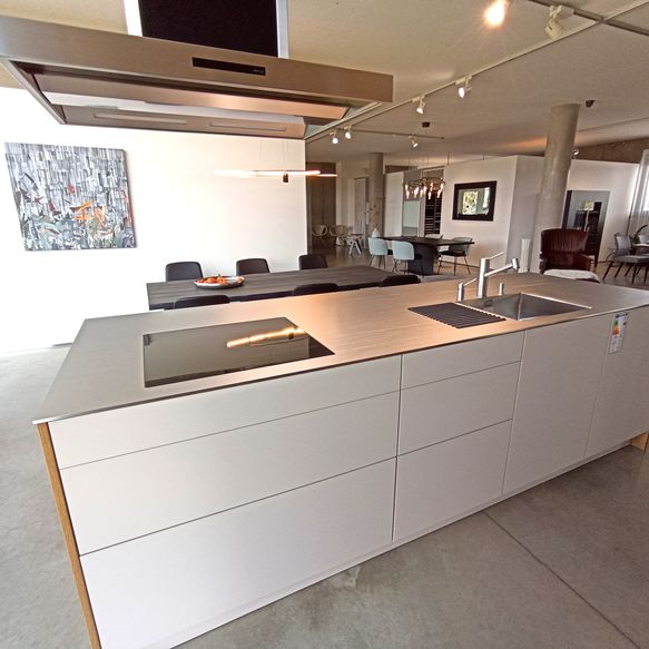 Moderne weiße Kücheninsel mit Arbeitsplatte aus warmgewalzten und hartverchromten Edelstahl