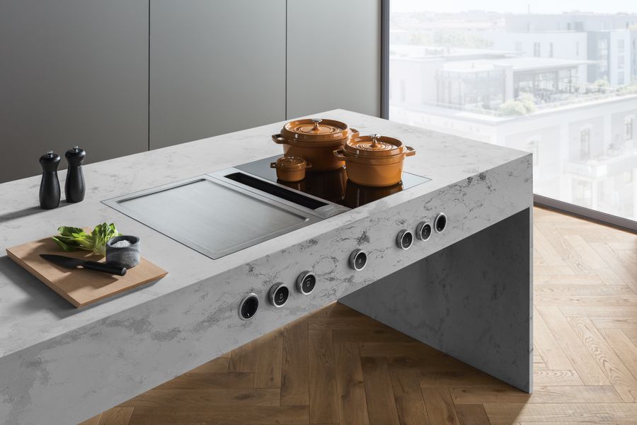 Kücheninsel mit Kochfeld, Töpfen und gekochten Speisen