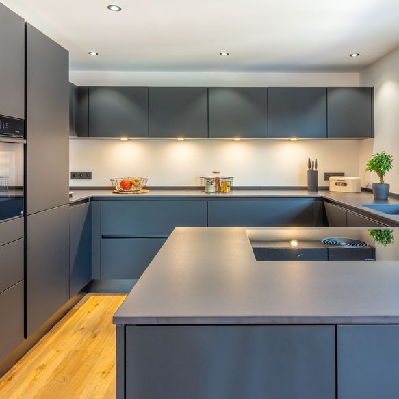 Schwarze, moderne Küche in G-Form