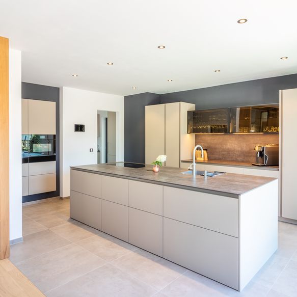 Moderne, offene Küche in beige mit Insel