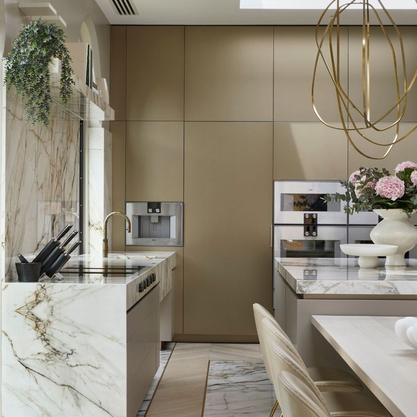 Luxuriöse Designküche in edlem Marmor mit matten Goldtönen