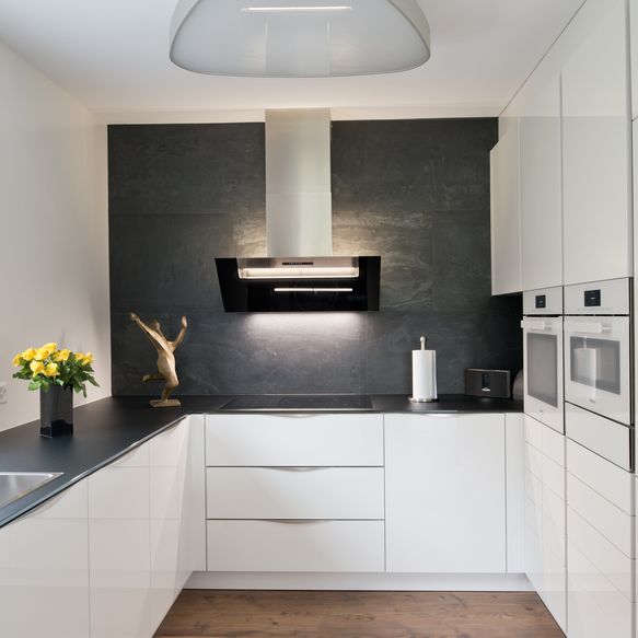 Schwarz-Weiße Küche in G-Form mit weißem Backofen