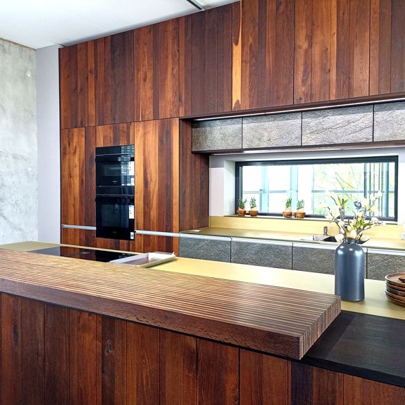 Küchenzeile mit Fronten aus Alteiche und Stein und Hubinsel aus Massviholz