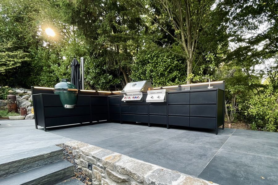 Schwarze Outdoor-Küche mit Keramikgrill und Gasgrill und mit LED-Beleuchtung