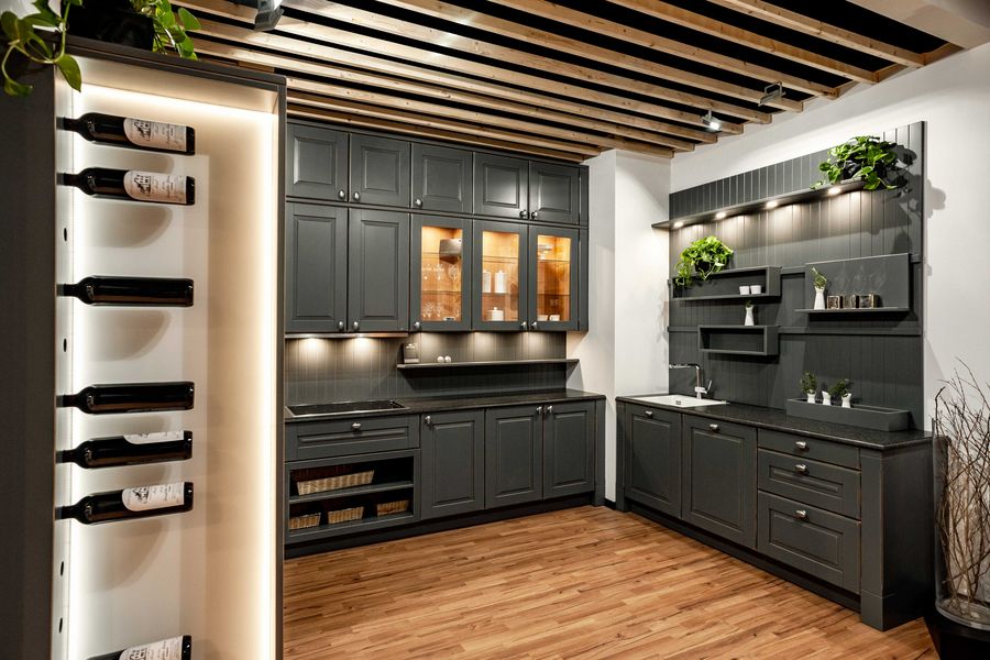 Graue Landhausküche mit Glastüren, Regalwand für Gewürze und Kräuter und Weinregal