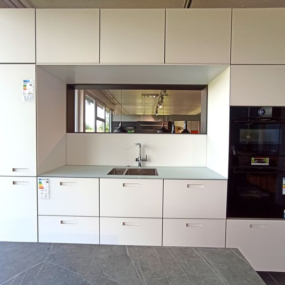 Weiße Küchenzeile mit Nische umgeben von Schränken im Rechteck