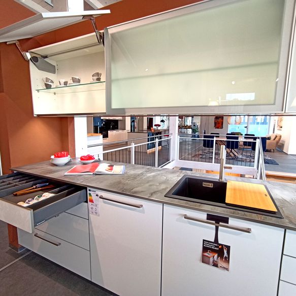 Klassische weiße Küchenzeile mit grauer Arbeitsfläche und Spüle