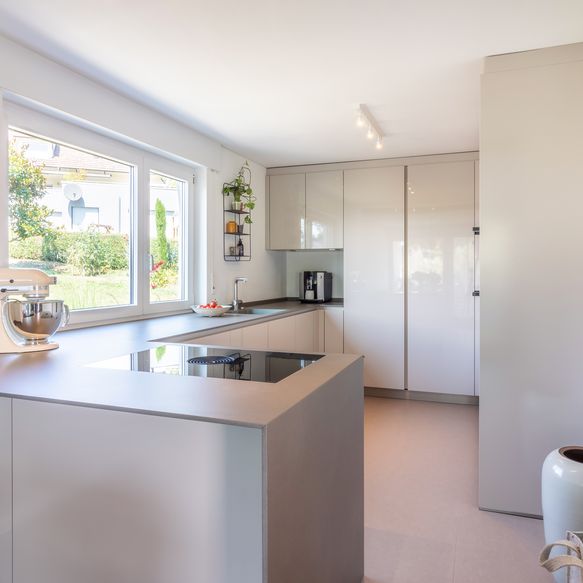 Hellgraue moderne Küche mit viel Stauraum