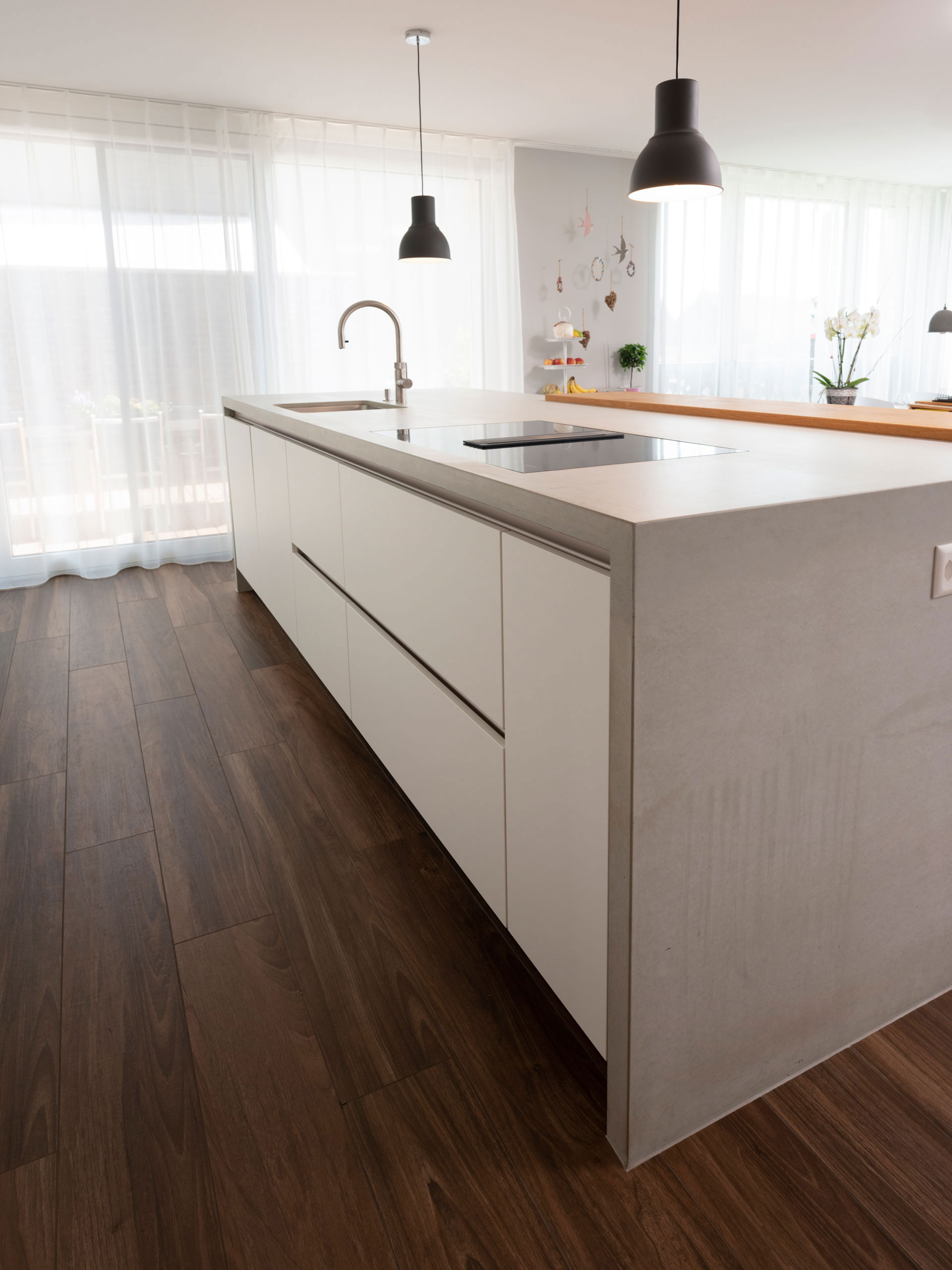Weiße Wohnküche mit Hochschrankwand, langer Insel und TV-Schrank mit Ablagefläche