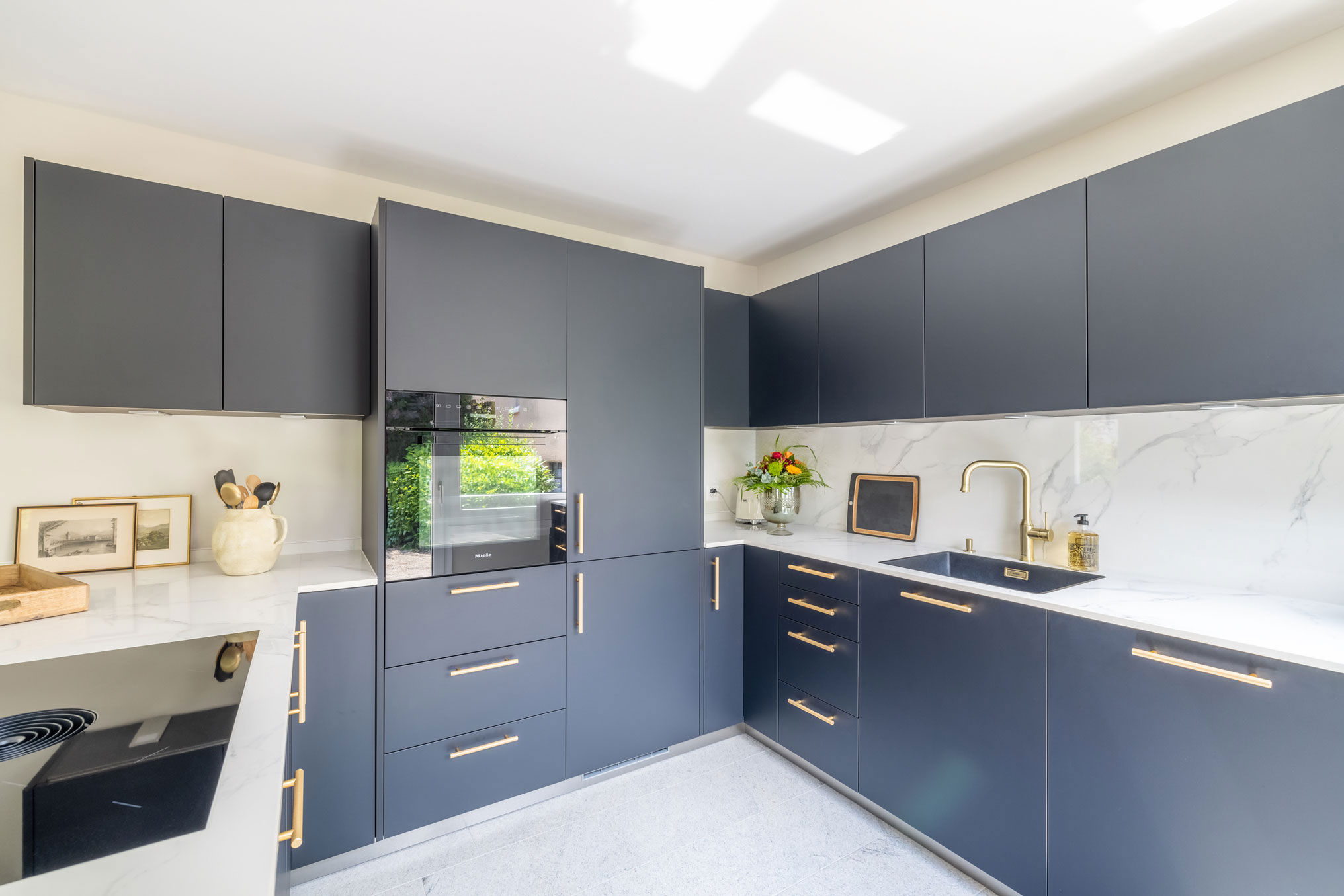 Edle Küche in U-Form in schwarz-weiß und goldenen Details