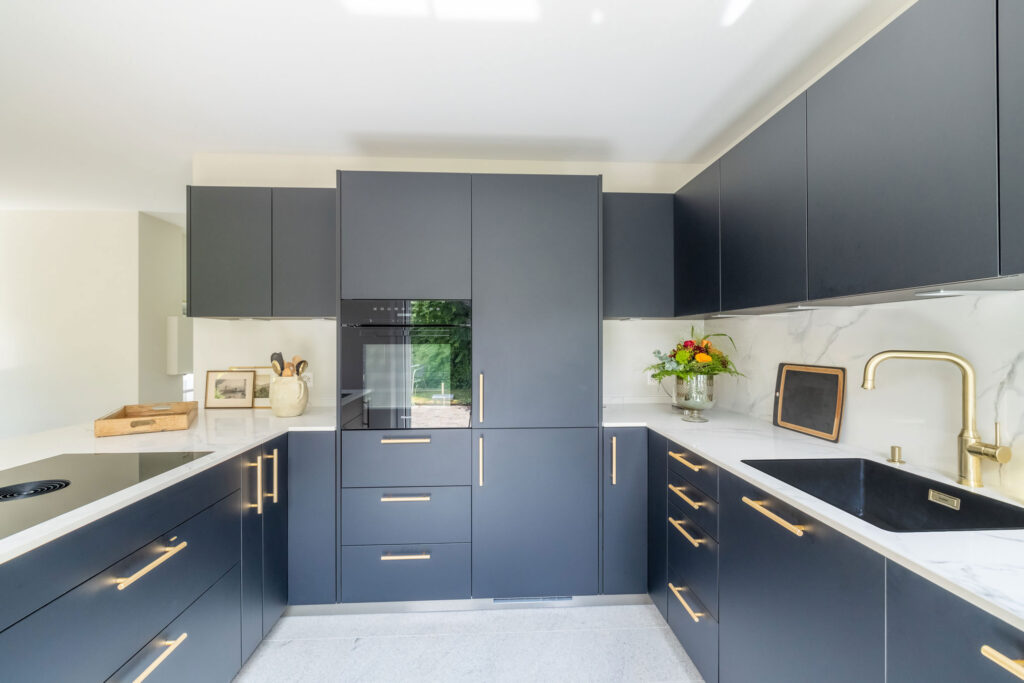 Edle Küche in U-Form in schwarz-weiß und goldenen Details