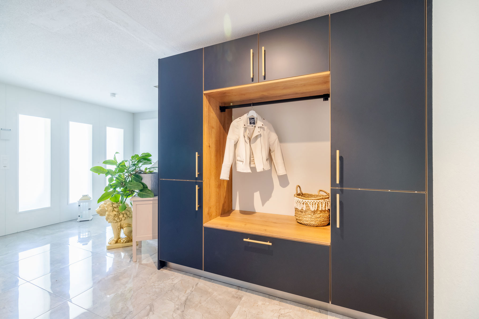 Garderobe in athrazit und Holzelementen mit goldenen Griffen