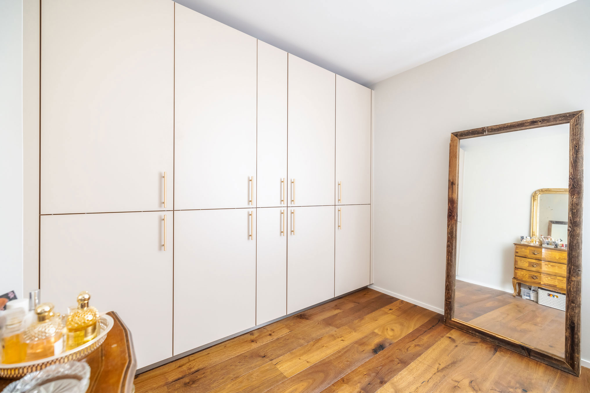 Weiße Garderobe als Hochränke mit goldenen Griffen