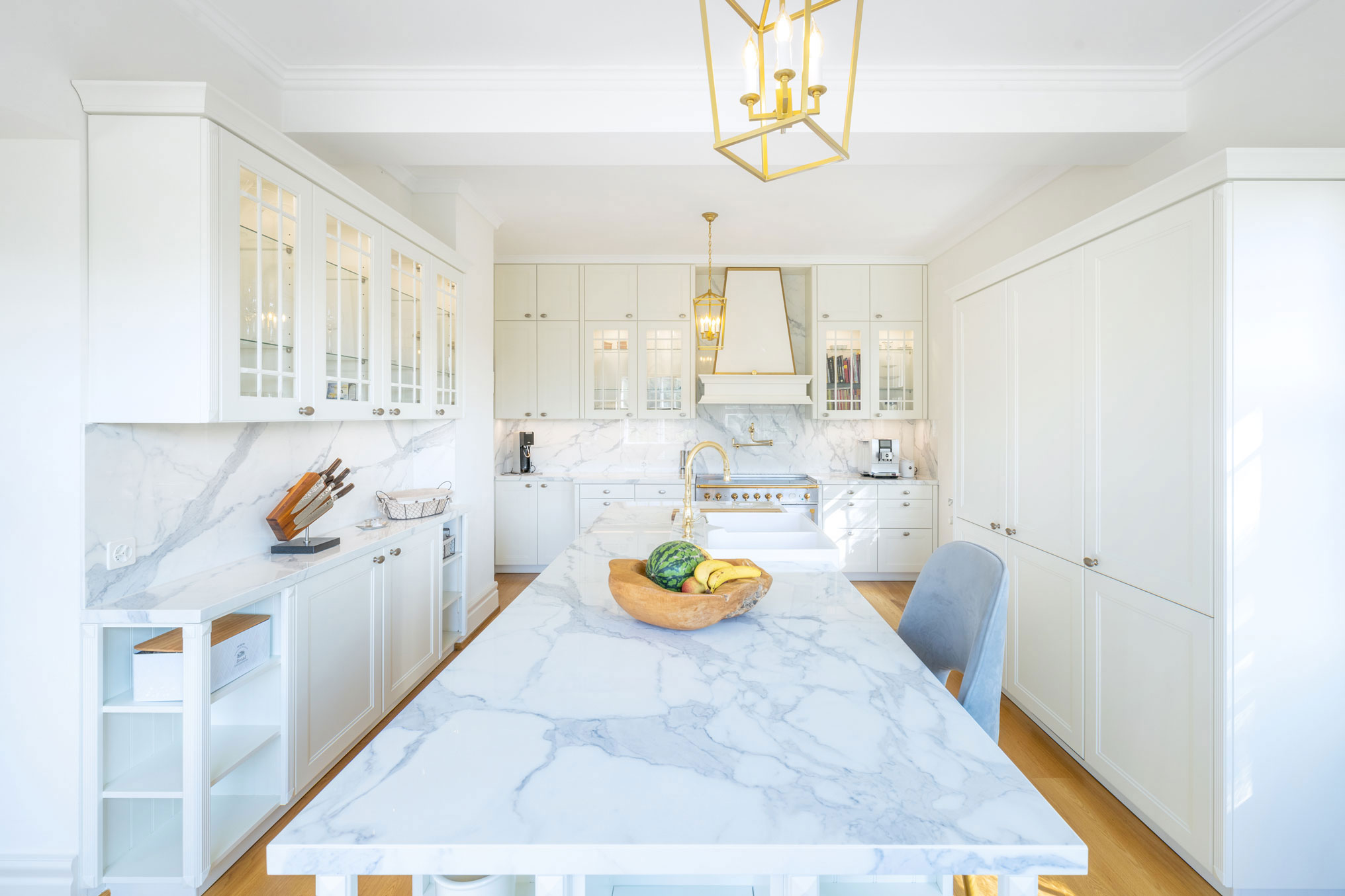 Weiße, elegante Landhausküche mit goldenen Elementen