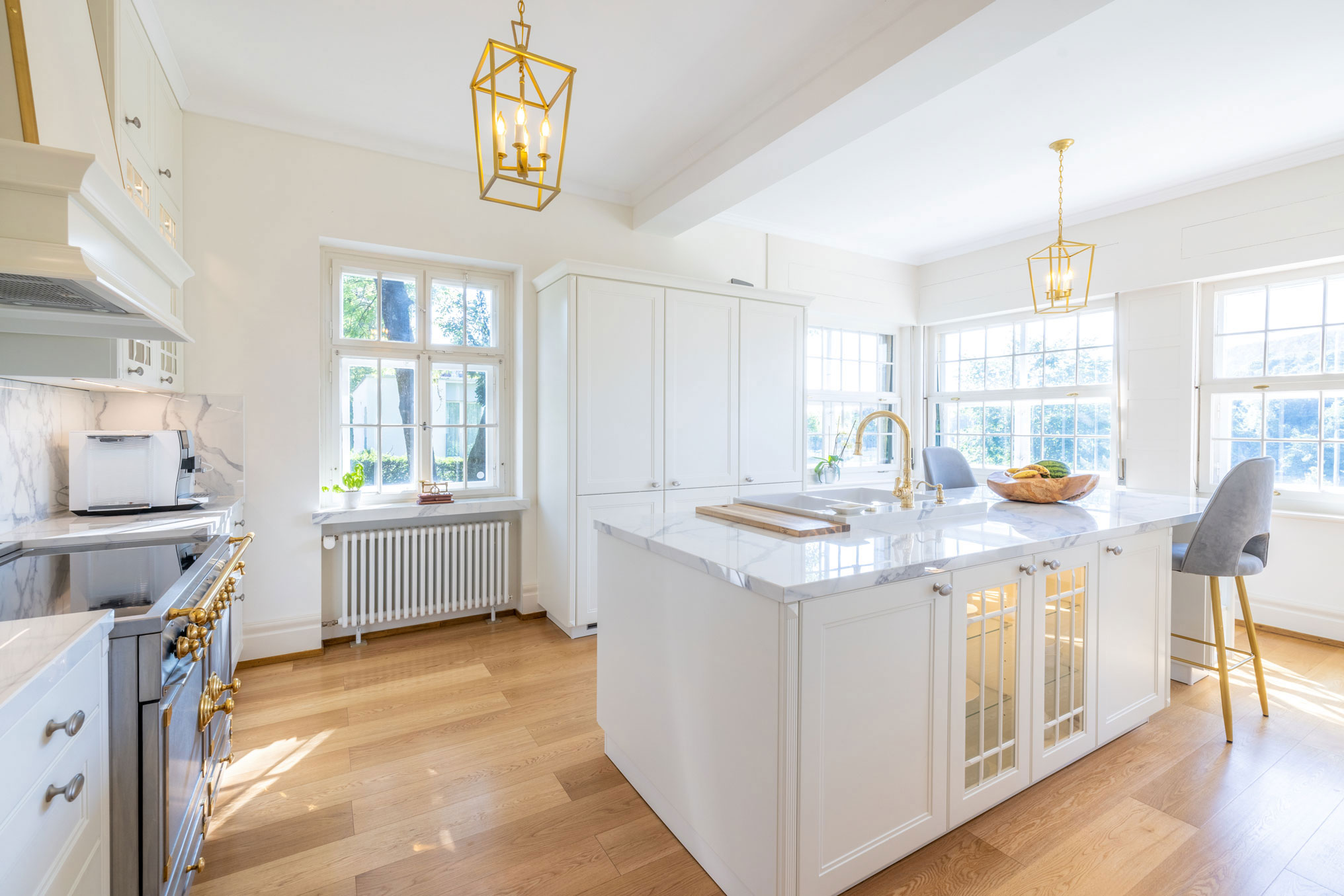 Weiße, elegante Landhausküche mit goldenen Elementen