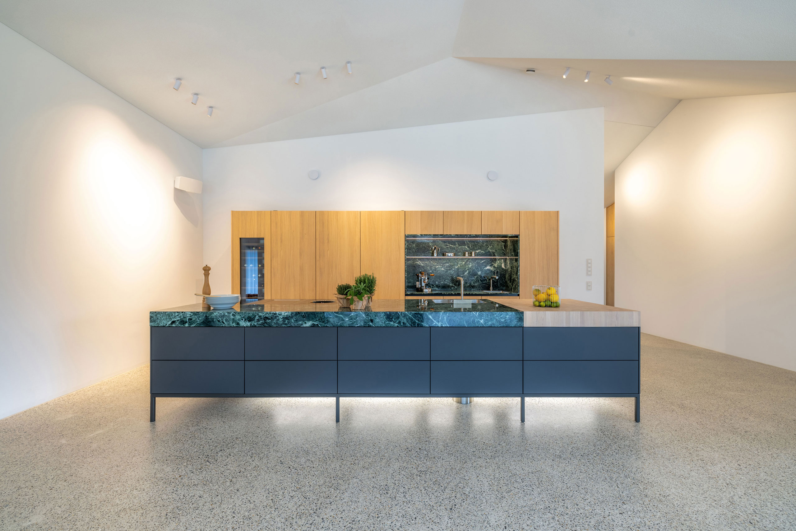 Lange, Design-Kochinsel mit grünem Naturstein