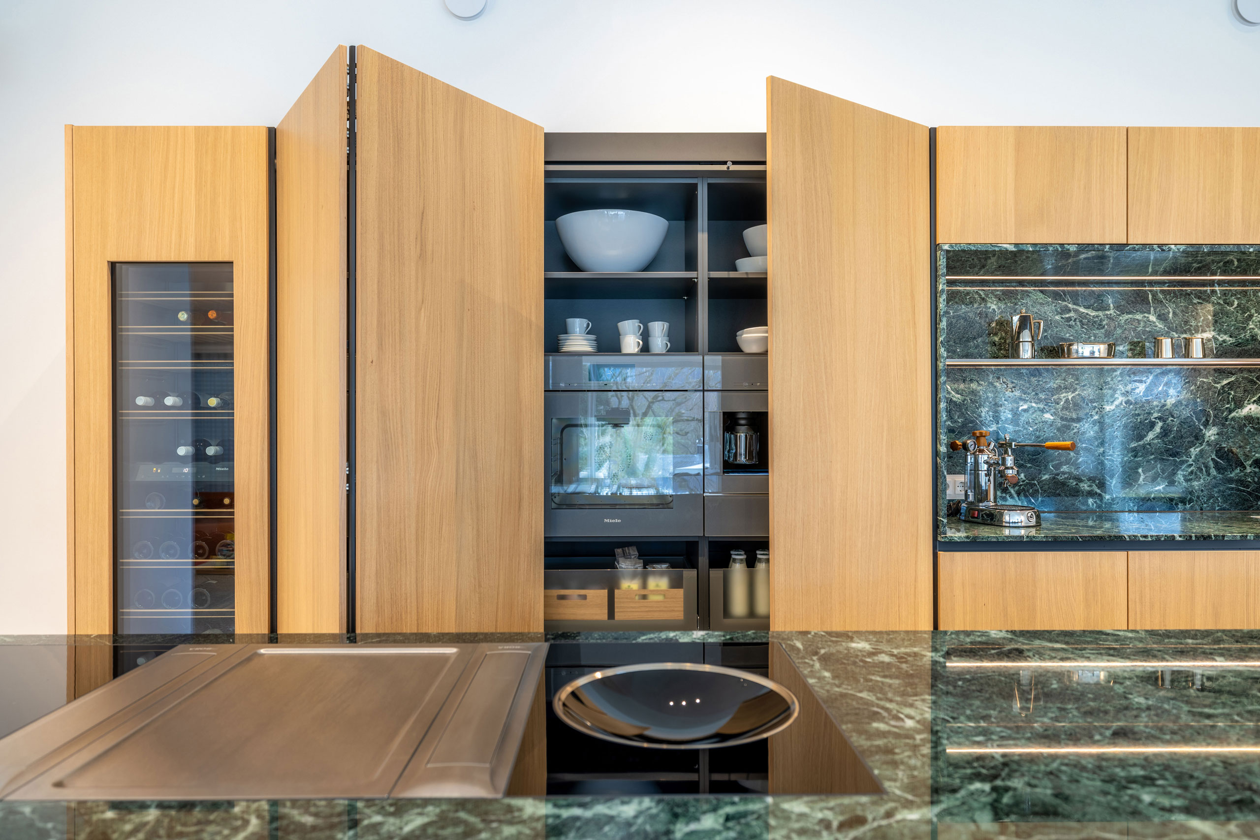 Lange, Design-Kochinsel mit grünem Naturstein