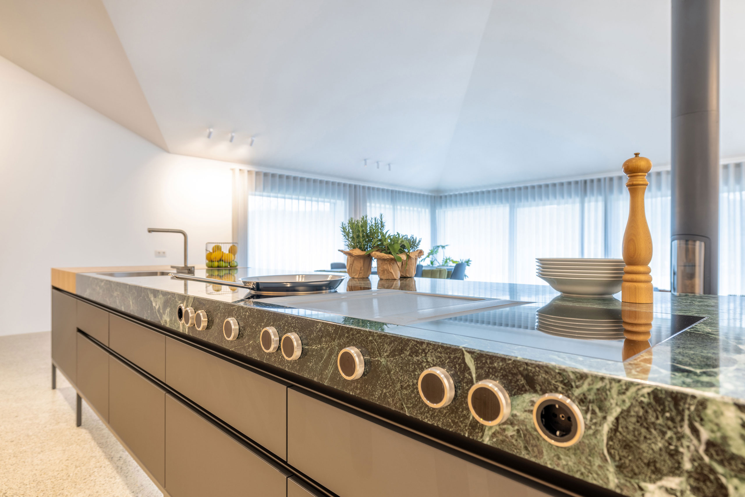 Lange, Design-Kochinsel mit grünem Naturstein