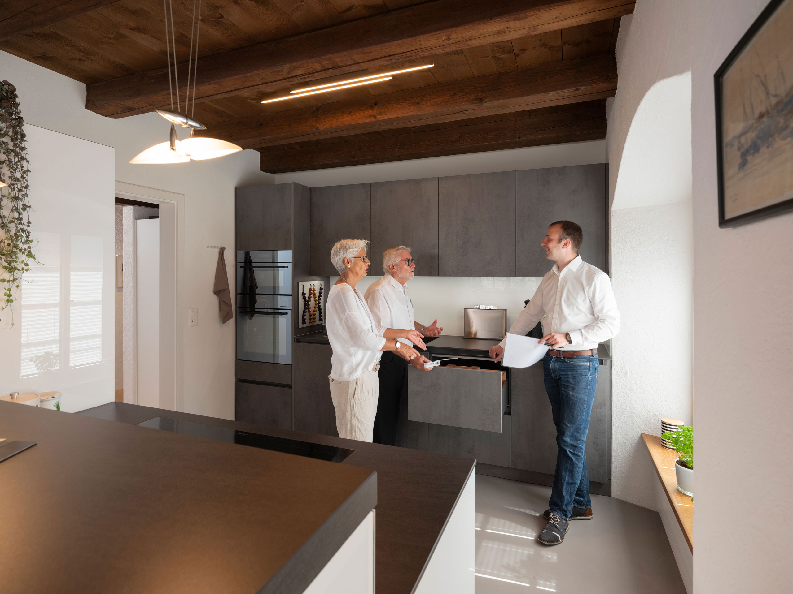 Graue Küche in Altbau-Wohnung mit Kunden und Berater