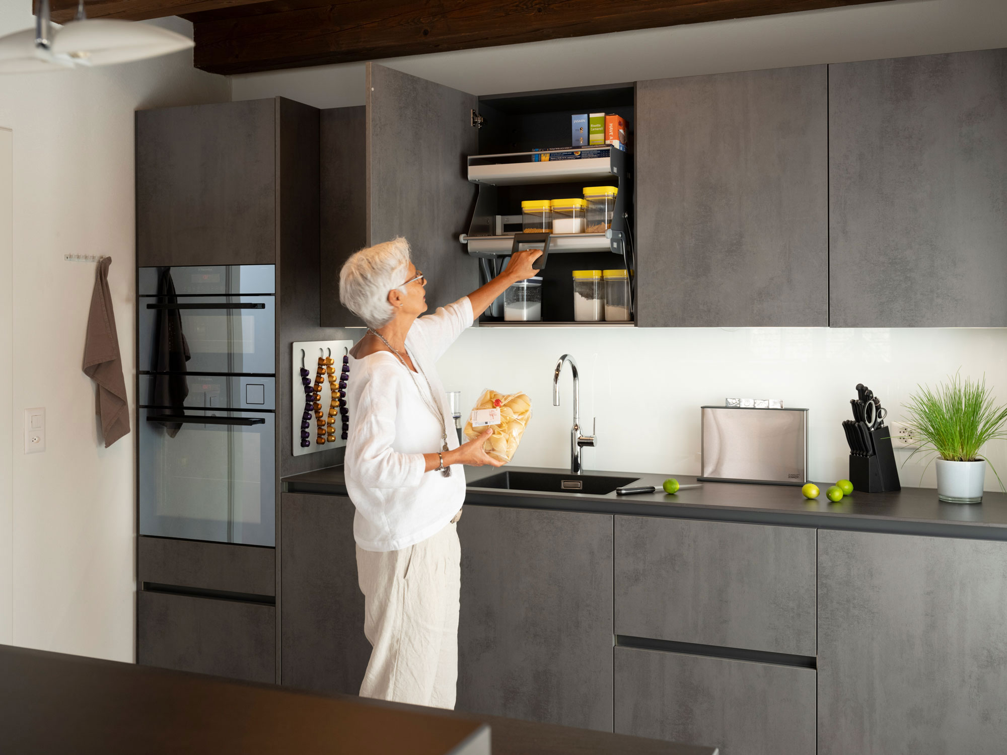 Graue Küche in Altbau-Wohnung mit Frau am Schrank
