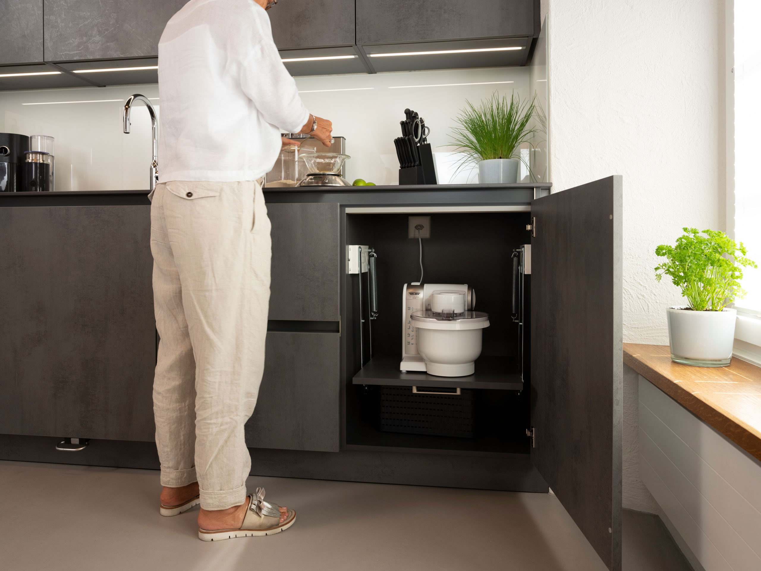 Graue Küche in Altbau-Wohnung mit Mann am Schrank