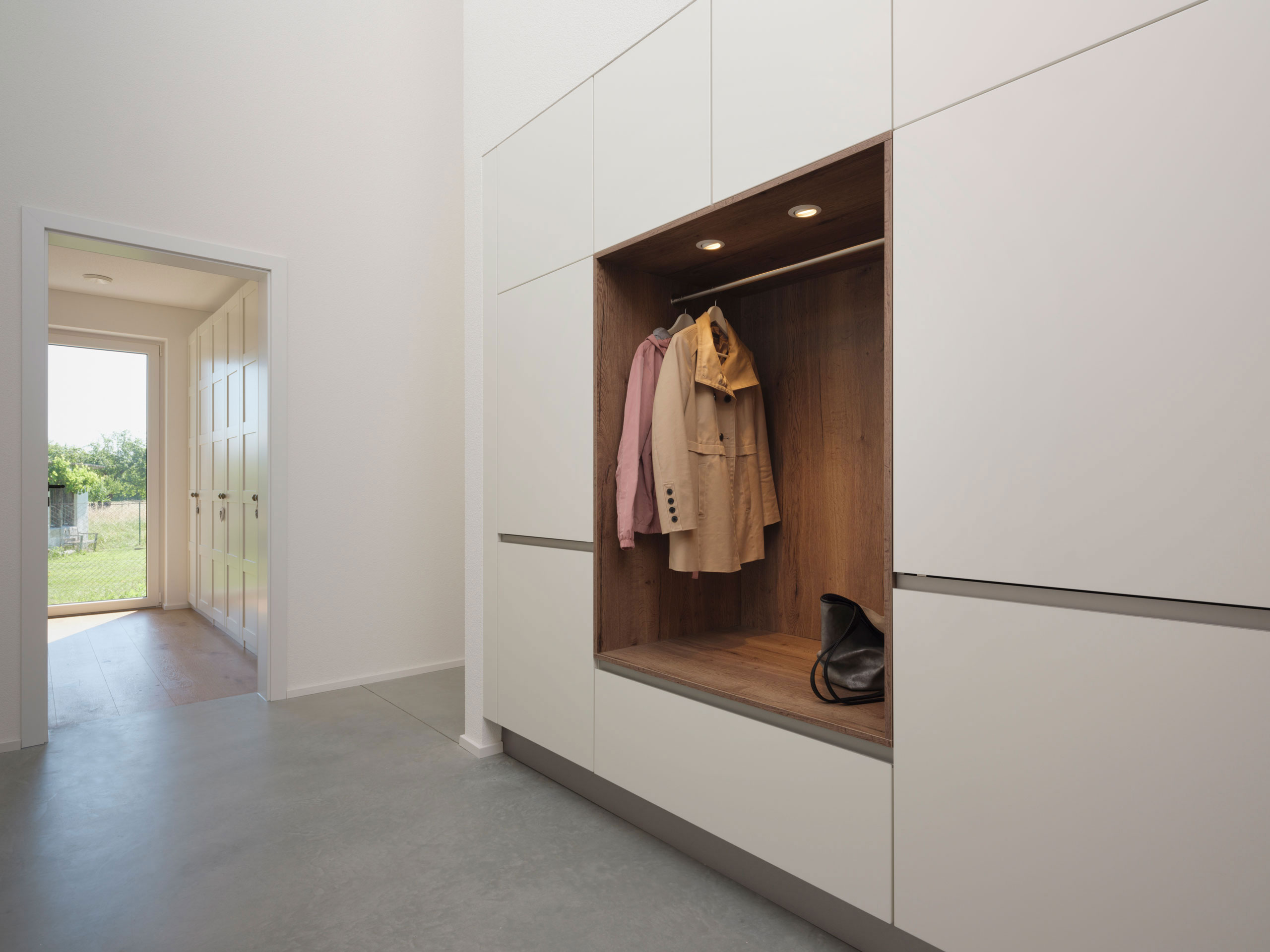 weiße, großflächige Garderobe mit Holzelementen