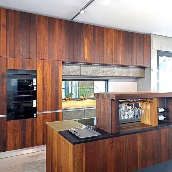 Ausstellungsküche von next125 in weiß und Holzoptik Fronten mit Naturstein-Arbeitsplatte