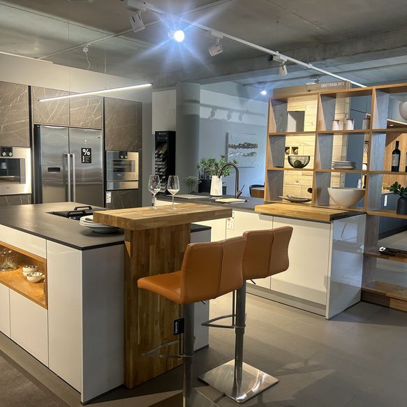 Ausstellungsküche in Küchenstudio mit zwei Inseln, Bar und Schrankwand