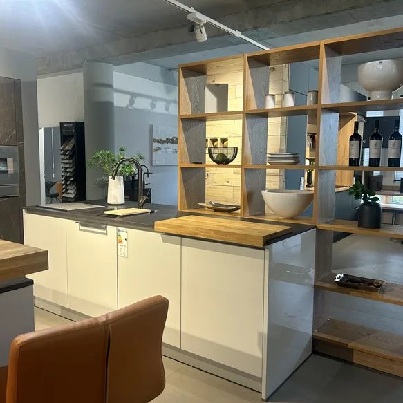 Ausstellungsküche in Küchenstudio mit zwei Inseln, Bar und Schrankwand und großem Regal