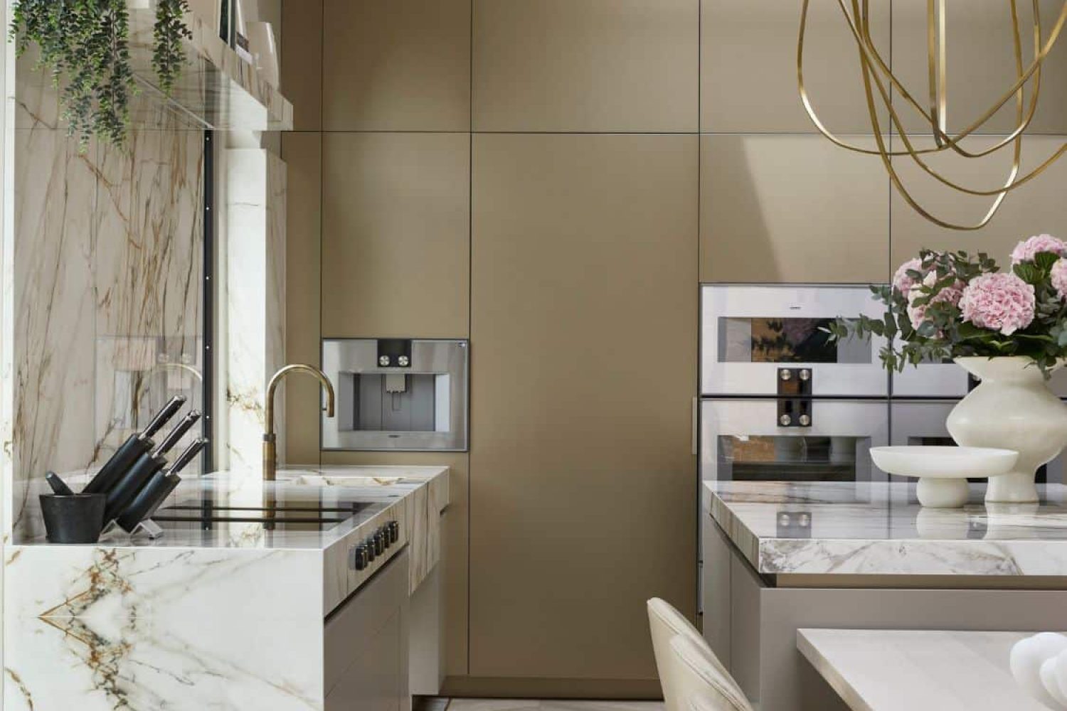Luxuriöse Designküche in edlem Marmor mit matten Goldtönen